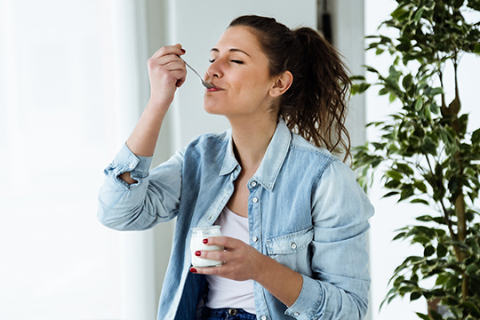 Woman eating yoghurt dairy