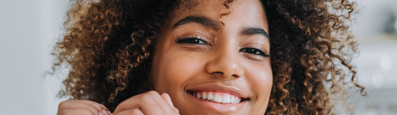 Young woman smiling confidently, representing healthy lifestyle and balanced blood sugar management