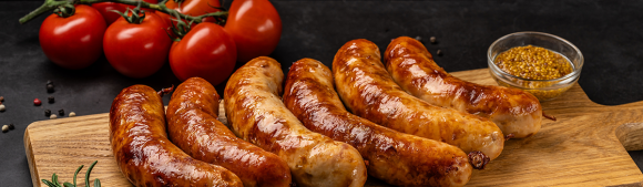 Grilled sausages served with tomatoes and mustard, showcasing savory meat alternatives application