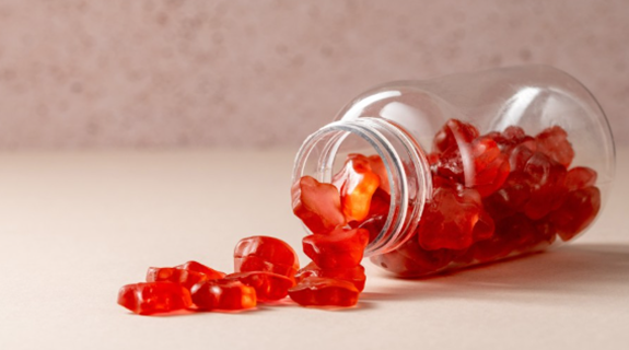 Fruit-flavoured gummy sweets spilling from a container