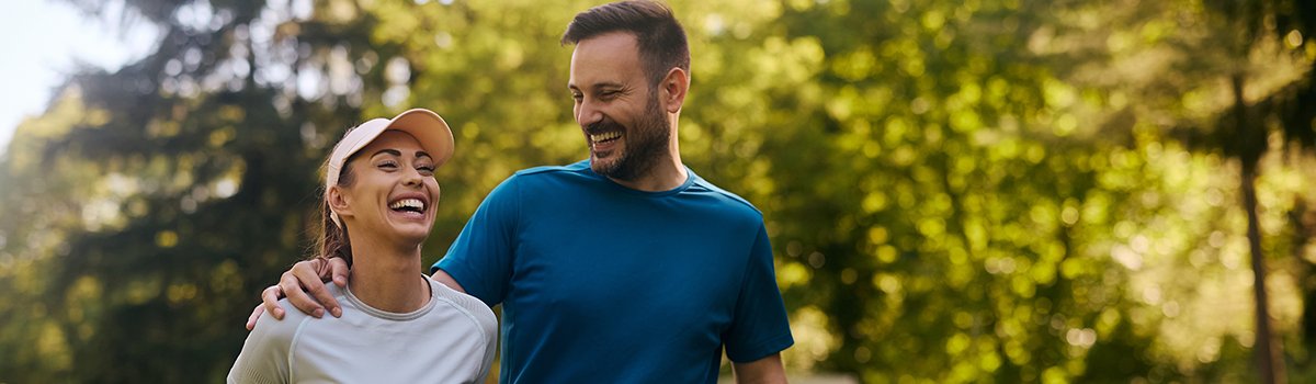 Smiling couple enjoying an outdoor walk together, representing an active lifestyle and digestive wellness.